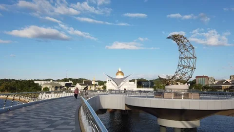 People walk through Sultan Omar Ali Saifuddin bridge Stock Footage 100938260
