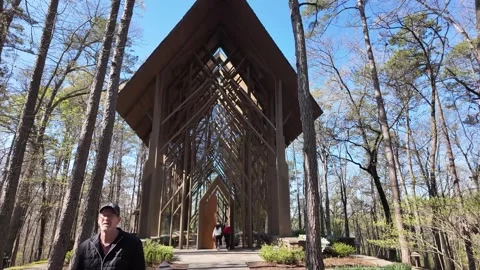 People walk toward the Chapel of the Trees in the spring forest. Stock Footage 345619100