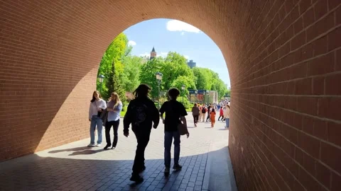 People walk under the arch of the Trinity Bridge of the Moscow Kremlin Stock Footage 197374122