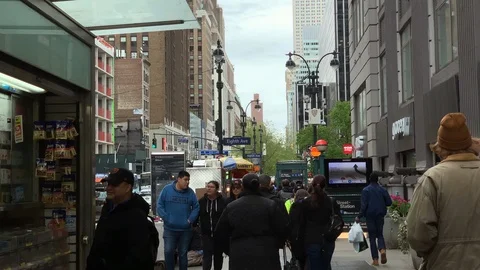People walking on 34th Street and 8th Avenue on chilly spring day Manhattan NYC Stock Footage