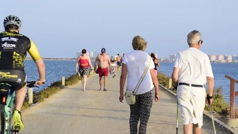 People walking along a path that divides two seas in Villananitos beach, Spain. Vídeos de archivo 112972592