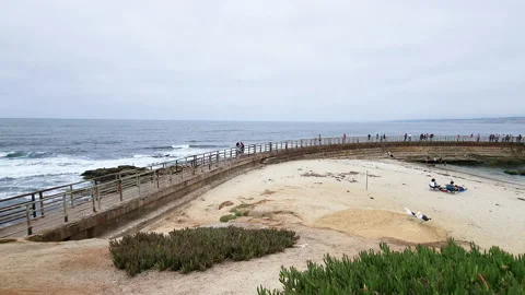 People walking along the path of railing wall in children's pool la jolla Stock-Footage 202058646