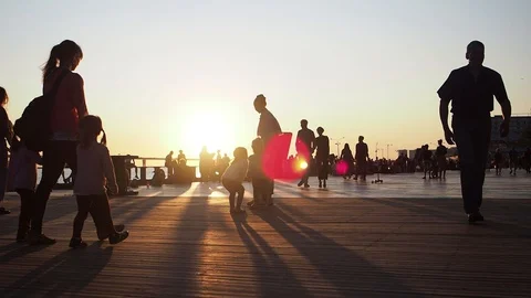 People walking along the promenade and enjoying gold sundown. Stock Footage 128546053