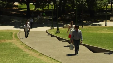People walking up and down the stairs in a park on a sunny day Stock Footage 160257558