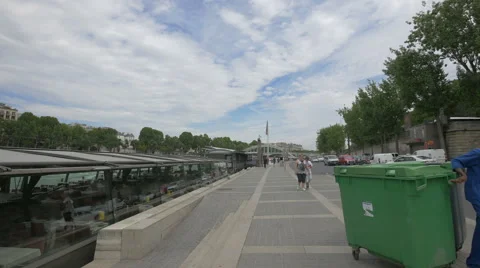 People walking and a man pulling a dumpster in Port de la Conference in Paris 스톡 동영상 59866073