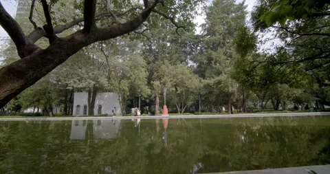People walking and reflecting pool in Lincoln Park, Polanco, CDMX Stock Footage 250360658