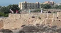 People walking around ancient walls in rocks. Tombs of the King in Pafos, Cyprus HD Footage
