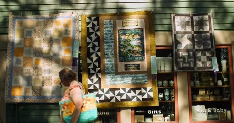 People walking around and looking at quilts at the Sisters Outdoor Quilt show Stock Footage 228723620