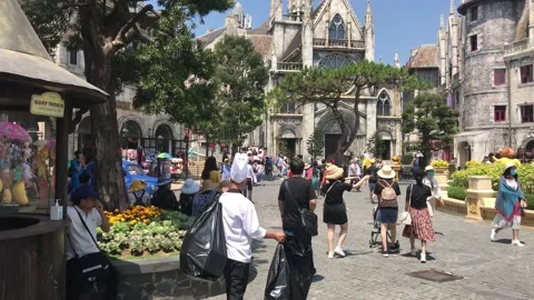 People walking around in front of old medieval European-styled castle buildings Video stock 151239760