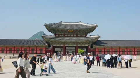 People walking around main gate at Gyeongbokgung Palace in seoul with busy Vídeo Stock 345020765
