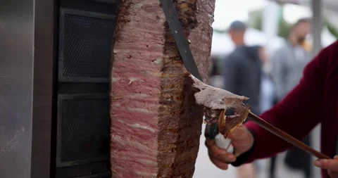 People Walking In The Background While Cutting Doner Doner With Doner Knife 库存影片 246413804