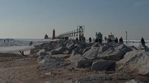People walking on the beach and lighthouse pier. Vídeo Stock 330994775