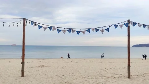People walking on the beach in a cold cloudy day Stock Footage 233463066