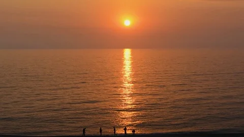 People walking on beach at sunset Stock-Footage 78564085