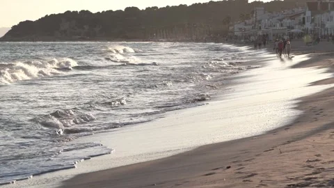 People walking on a beach at sunset Stock Footage 252597312