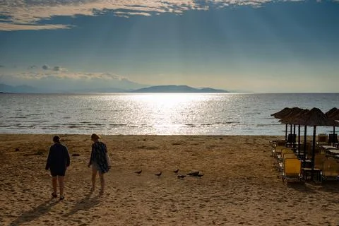 People walking on the beach at sunset Stock Photos