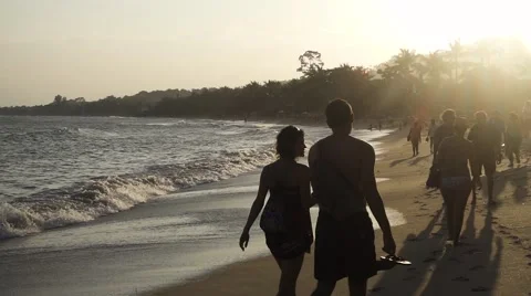 People walking on the beach at sunset. Slow motion Stock Footage 58743596