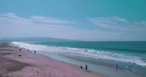 People walking on beach with waves and blue sky 스톡 동영상 339519969