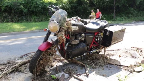 People walking behind flood damaged motorcycle. Ellicott City, Maryland. Stock Footage 70537486