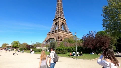 People walking beside the Impressive Eiffel Tower in Paris Stock Footage 191986339