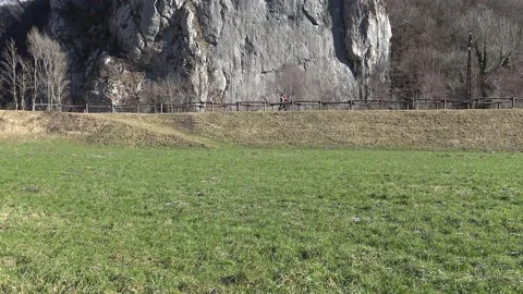 People walking between meadow and rocky mountain Video stock 150858932