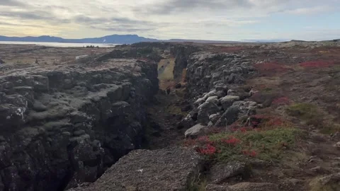 People walking between the tectonic plates in the in Thinvellir national park in 動画素材 257253524