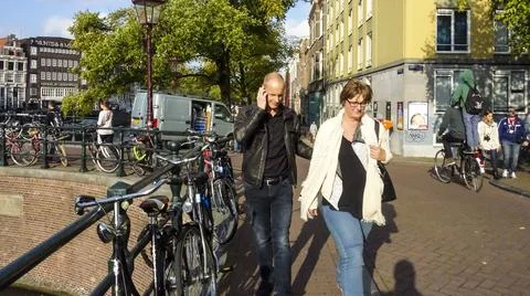 People walking by bikes Stock Photos