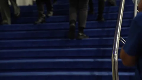 People walking up blue carpeted event stairs with stainless steel railings in Stock Footage 322153395