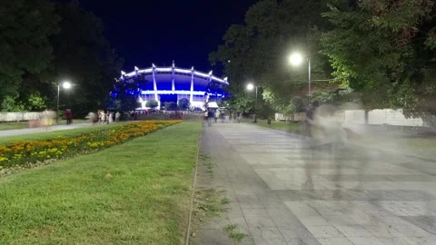 People walking as blurred motion ghosts at night in an urban park Vidéo 342658094