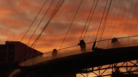 People walking on a bridge at sunset Stock Footage 302475008