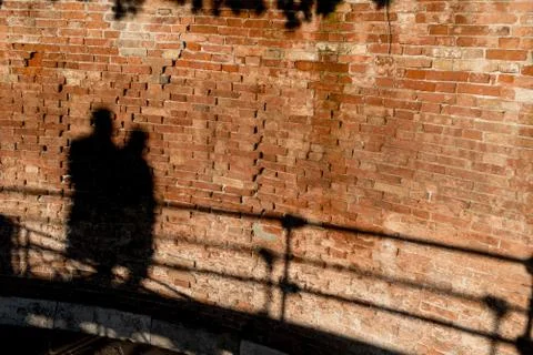 People walking, casting shadows on a wall 写真素材