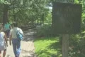 People walking into Central Park past the Strawberry Fields sign Footage