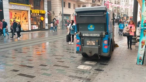 People walking, cleaning machine sweeping pavement at Istiklal street Stock Footage 96548928
