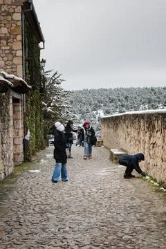 People walking cobblestone path enjoying winter village experience Foto stock