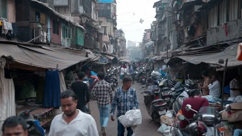 People walking on a congested road with bikes, dingy shops in a old buildings Stock Footage 328501526