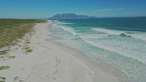 People walking on deserted beach, Table mountain in background, South Africa Stock Footage 295994105
