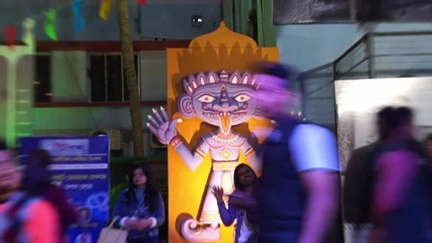 People walking by a Devil or Demon statue. Night light. Video stock 230022928