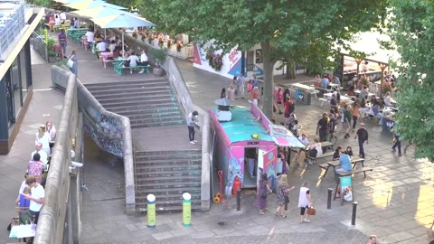 People walking at dining outside along the Southbank of the River Thames Stock Footage 205410974