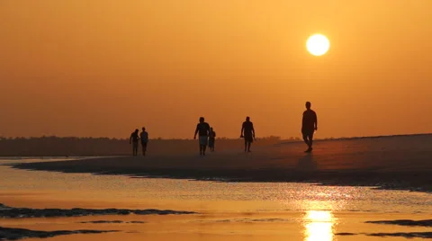 People Walking Down Beach at Sunset - Water in Foreground Nature Stock Footage 55273222