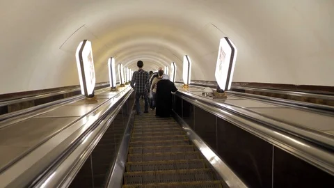 People walking down the long escalator in the metro Stock Footage 124306754