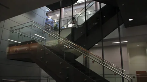 People walking down a modern stairway inside a building Stock Footage