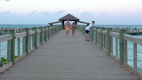 People walking down a pier in the Caribbean Видео 133805833
