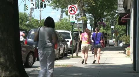 People walking down sidewalk and car parallel parking Stock Footage 8981393
