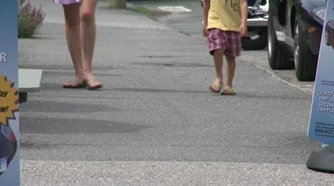People walking down the sidewalk past a sidewalk sign (2 of 2) Stock-Footage 10771717