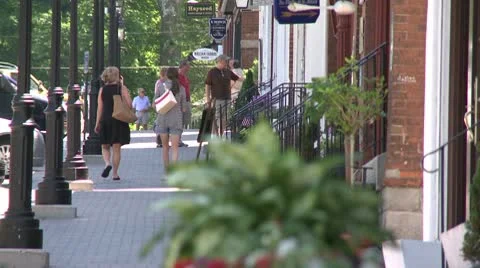 People walking down streetlight lined sidewalk Video stock 8981560