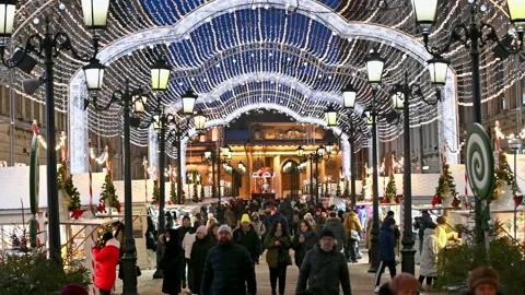 People walking in evening time on a decorated and lit christmas fair Stock Footage 168408666