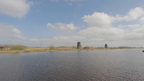People walking on footpath near traditional Windmills in the Netherlands Stock Footage