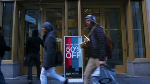 People walking in front of a glass window with the sale up to 50% off. Stock Footage 278017440