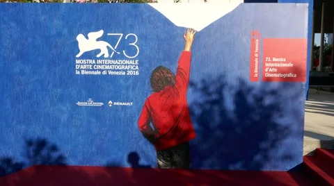 People walking in front of the poster of 73th Venice international film festival Stock Footage 68738061