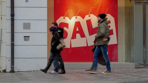 People walking in front of a shop window with a big sale sign Video stock 45831028